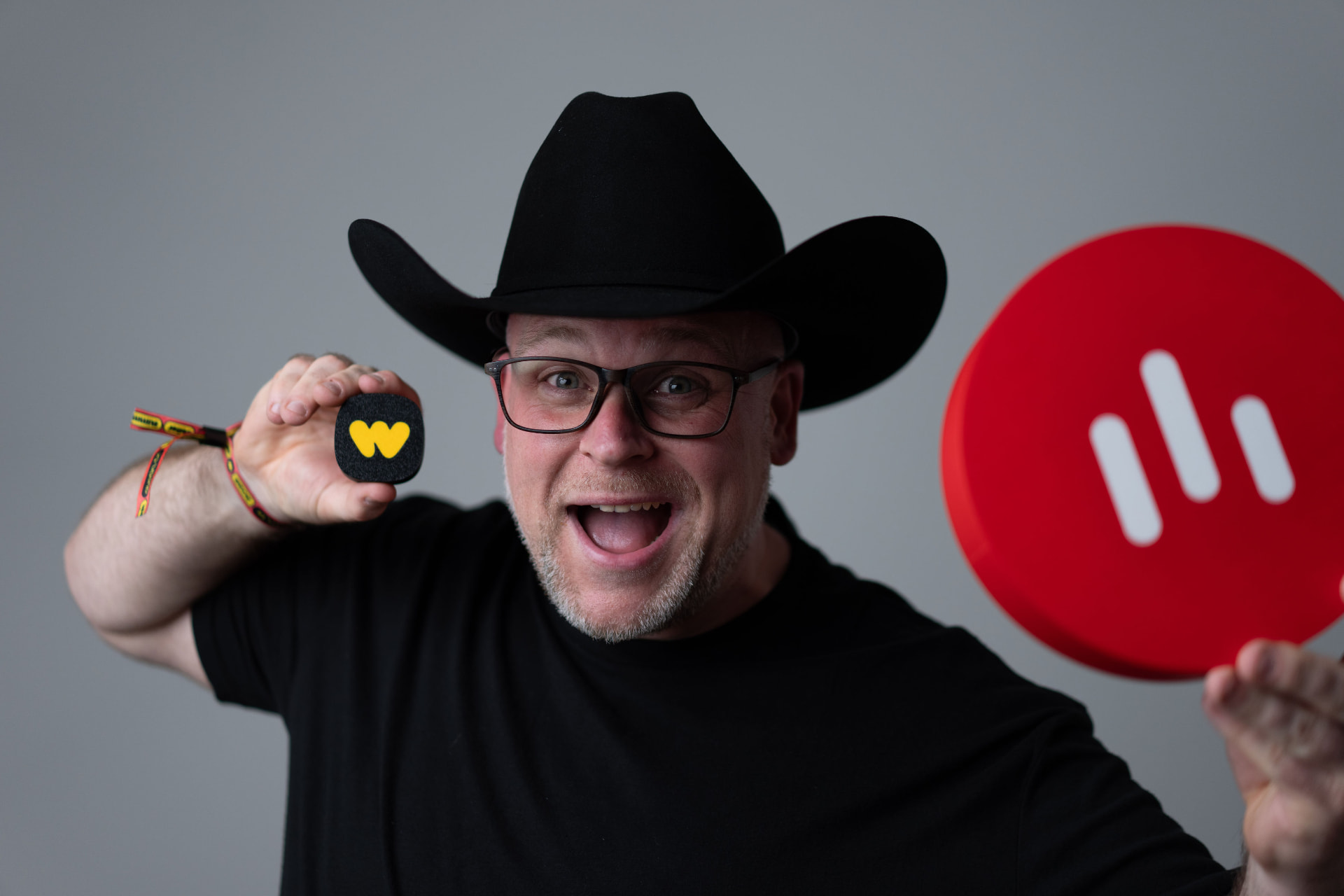 Darren Millar, founder of Meetup Hub, in a black cowboy hat holding a Whatnot squishy and a red Whatnot logo sign